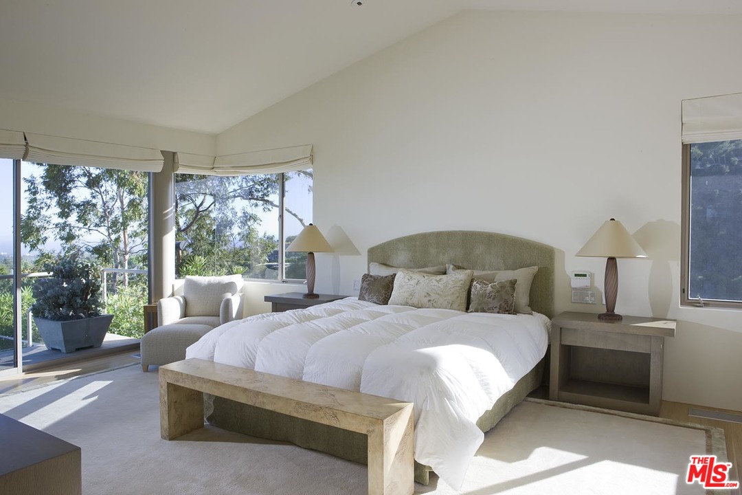 1827 Westridge Road Los Angeles, CA 90049 - Photo 12 of 34 a bedroom with a bed lamp and window