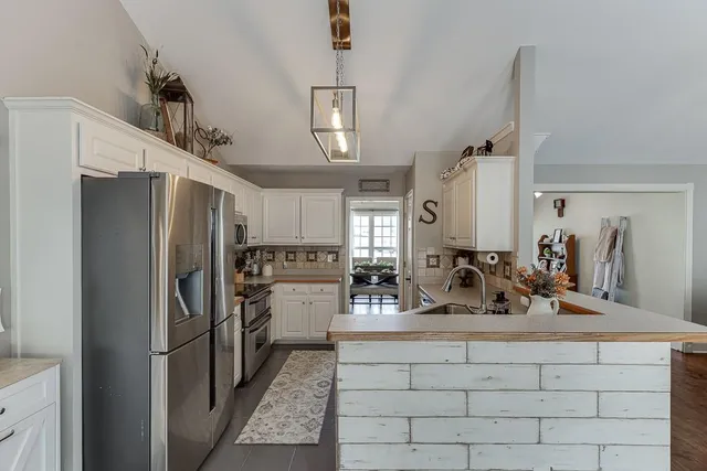 a kitchen with refrigerator and cabinets