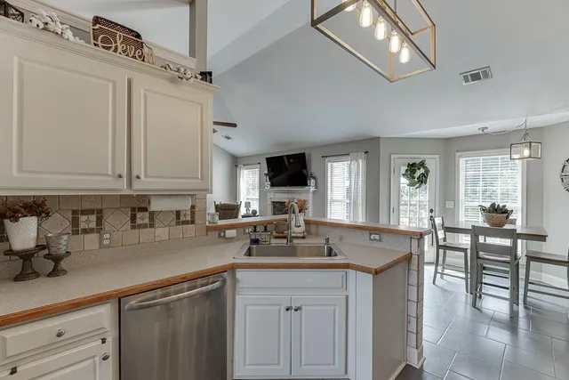 a kitchen with granite countertop a sink stainless steel appliances and cabinets
