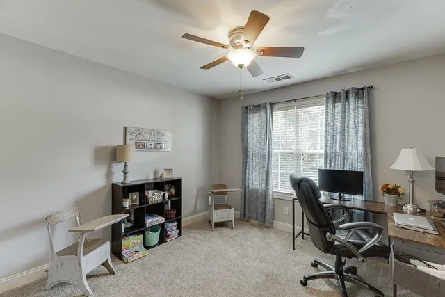 a view of a workspace with furniture and a window