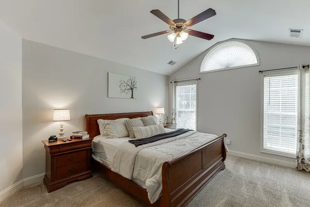 a spacious bedroom with a bed and a chandelier