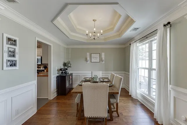 a dining room with furniture window and wooden floor
