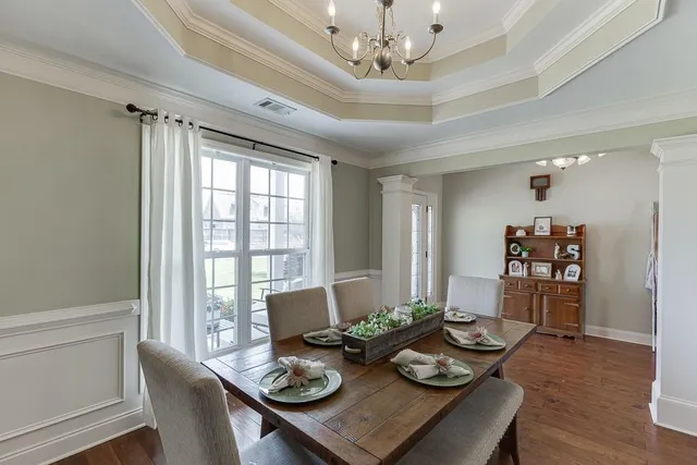 a view of a dining room and livingroom with furniture wooden floor and a chandelier