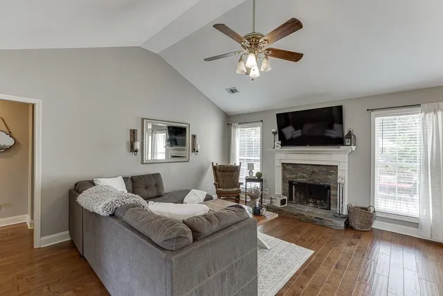 a living room with furniture a fireplace and a flat screen tv