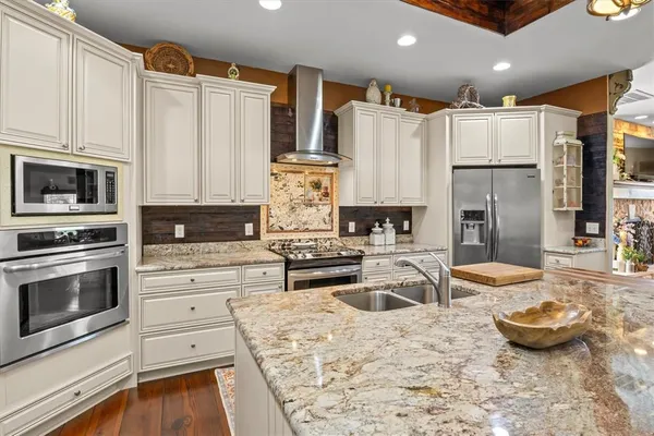 a kitchen with stainless steel appliances granite countertop a stove refrigerator sink and cabinets