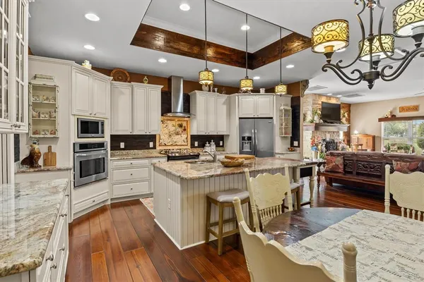 a view of a dining room with furniture a chandelier and wooden floor