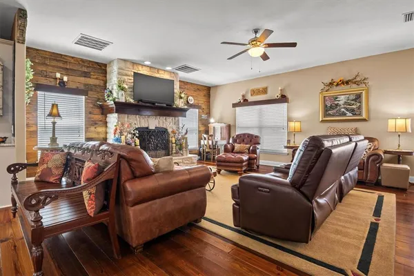 a dining room with wooden floor a chandelier a wooden table and chairs