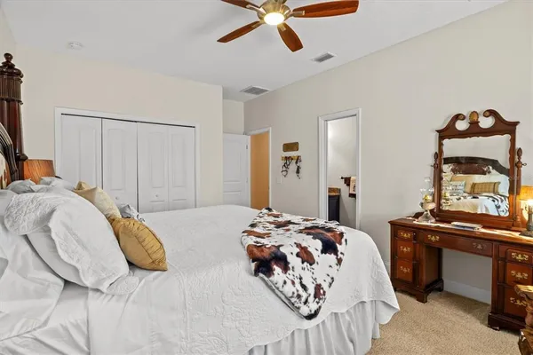 a bedroom with a bed and a lamp on dresser