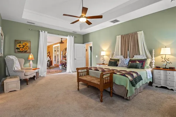 a spacious bedroom with a bed and a chandelier