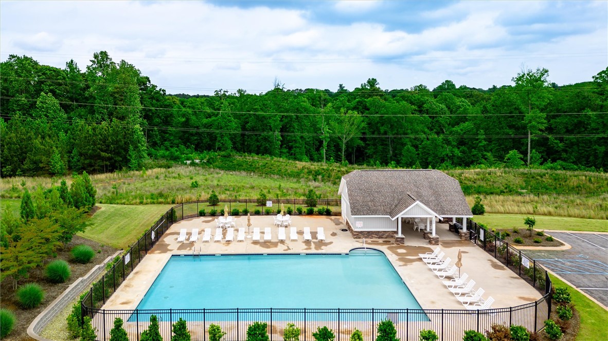 191 Light Spring Road Easley, SC 29642 - Photo 34 of 34 An inviting swimming pool and clubhouse awaits, nestled beside a vast, verdant landscape.