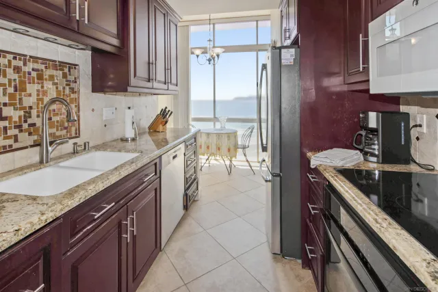 a kitchen with granite countertop a sink stove and cabinets