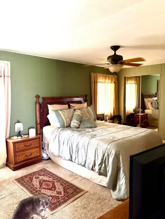 a bedroom with a large bed and a chandelier