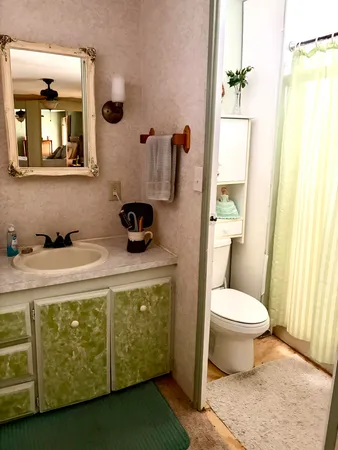 a bathroom with a toilet sink and mirror