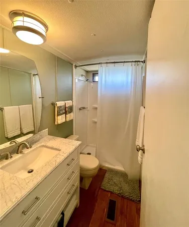 a view of an empty room with window a kitchen area with front door