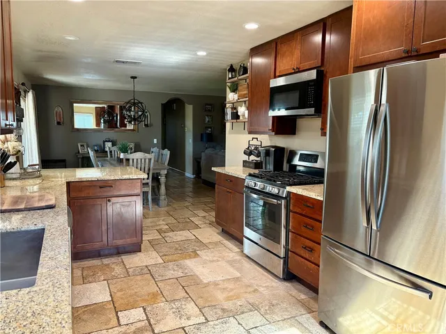a kitchen with stainless steel appliances granite countertop a refrigerator and a stove