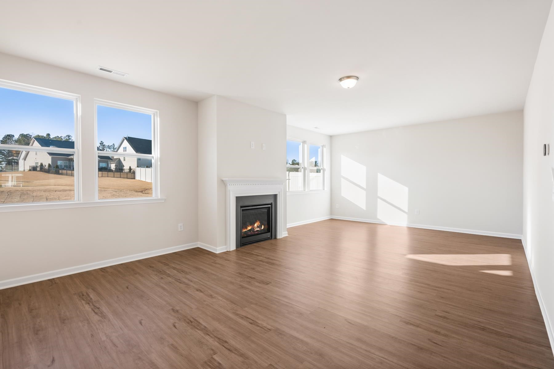158 Karlov Road Garner, NC 27529 - Photo 12 of 37 a view of empty room with wooden floor and fireplace