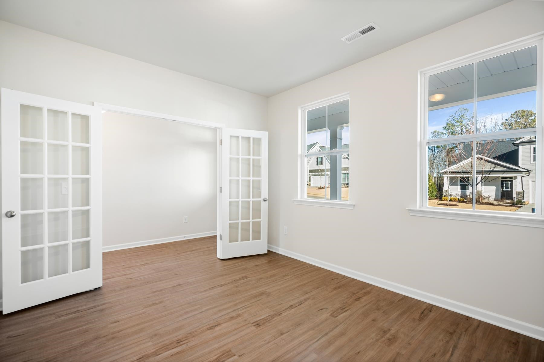 158 Karlov Road Garner, NC 27529 - Photo 4 of 37 an empty room with wooden floor and windows
