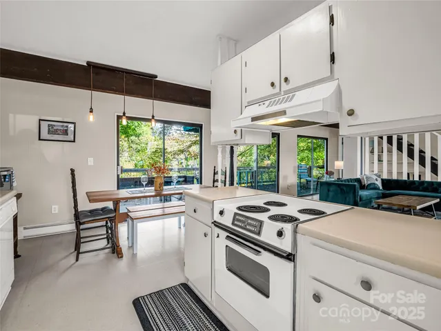 a kitchen that has a stove and a table chair in it