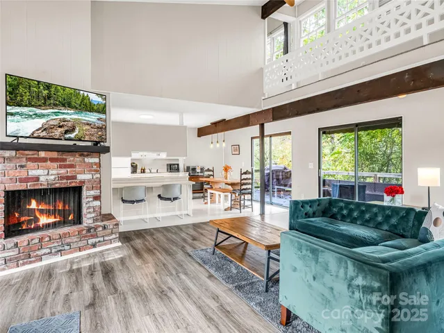 a living room with furniture a fireplace and a floor to ceiling window