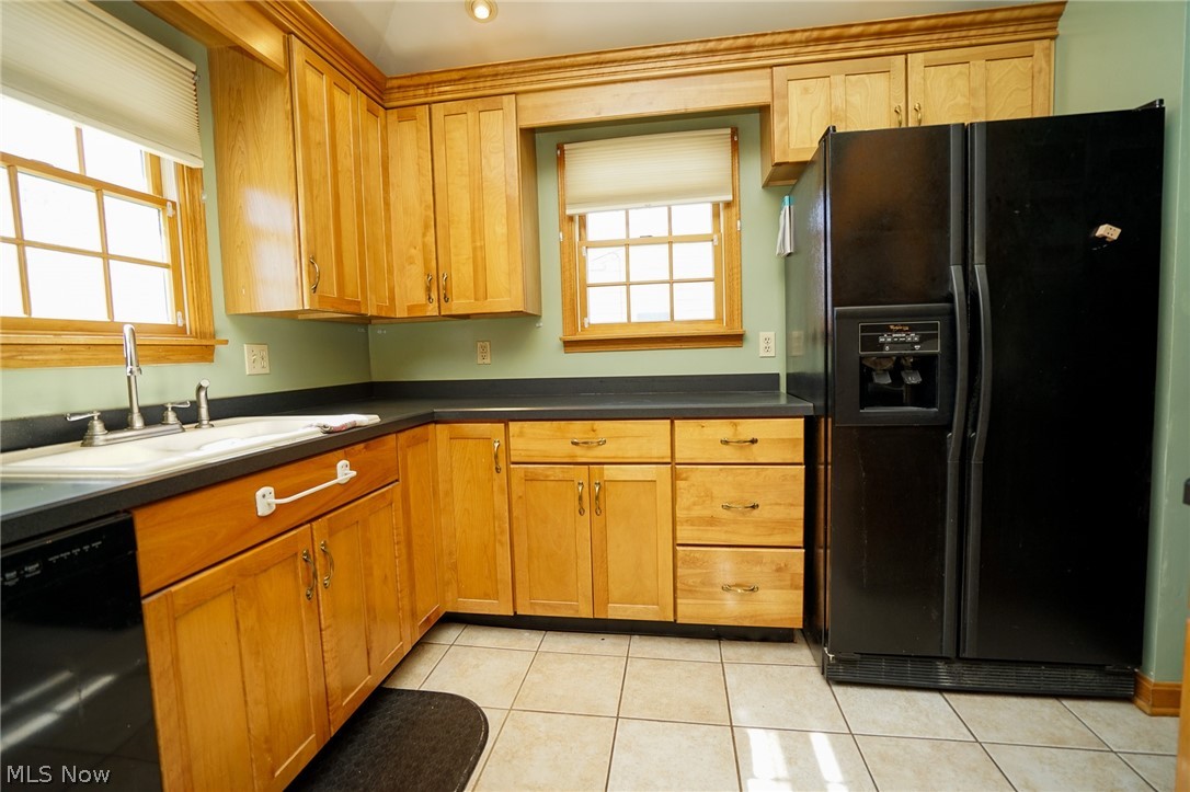 453 Omar Street Struthers, OH 44471 - Photo 15 of 27 Kitchen with black appliances, dark countertops, light tile patterned floors, and wood finish cabinets