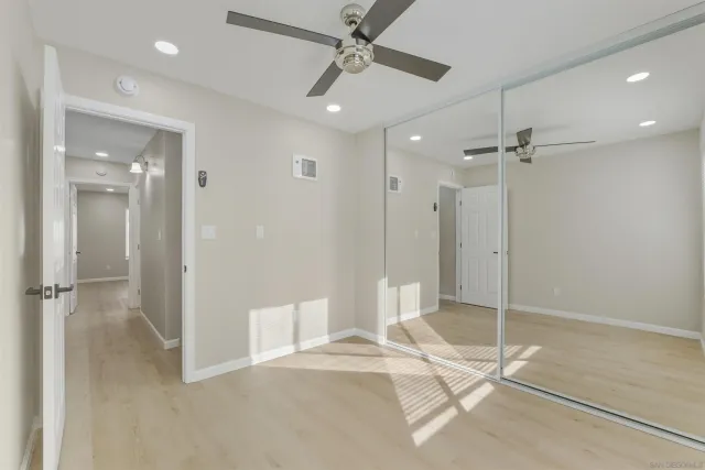 a view of a livingroom with a chandelier fan and windows