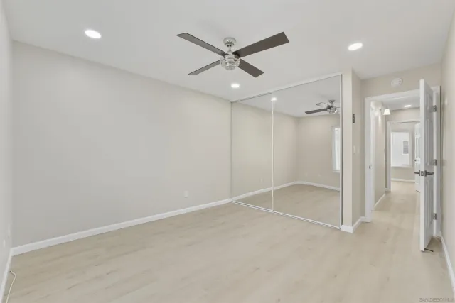 an empty room with closet and windows