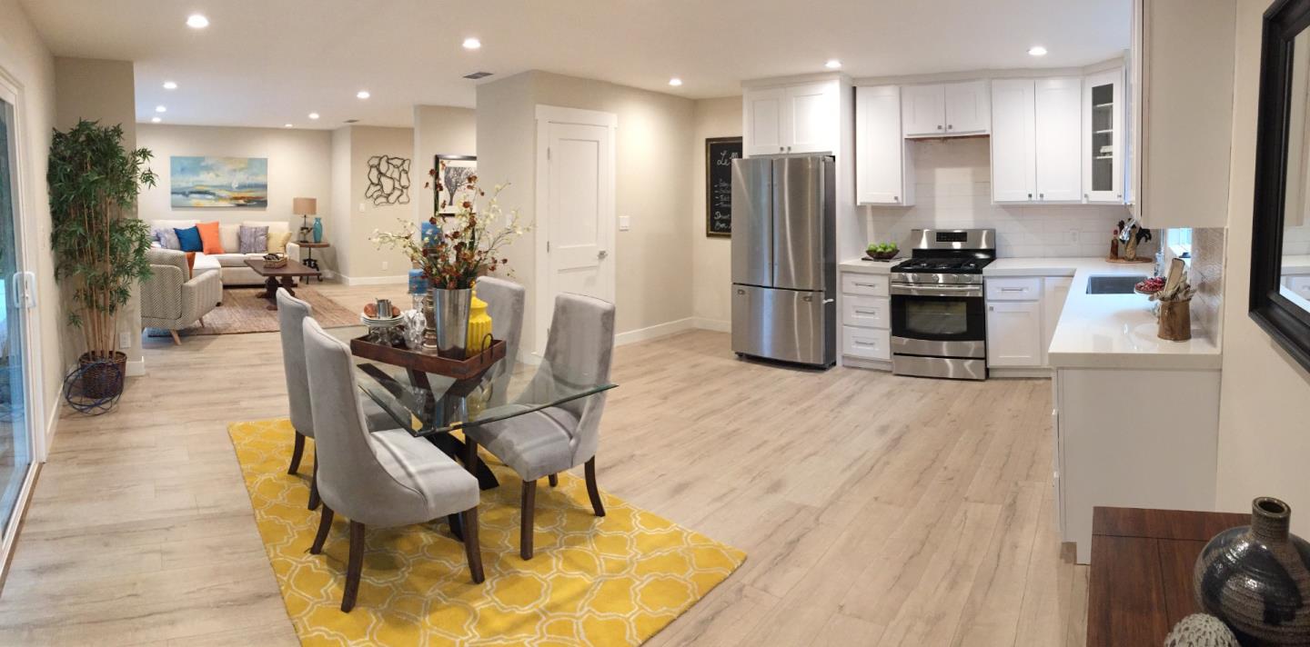 a kitchen with stainless steel appliances kitchen island granite countertop a refrigerator and a stove top oven