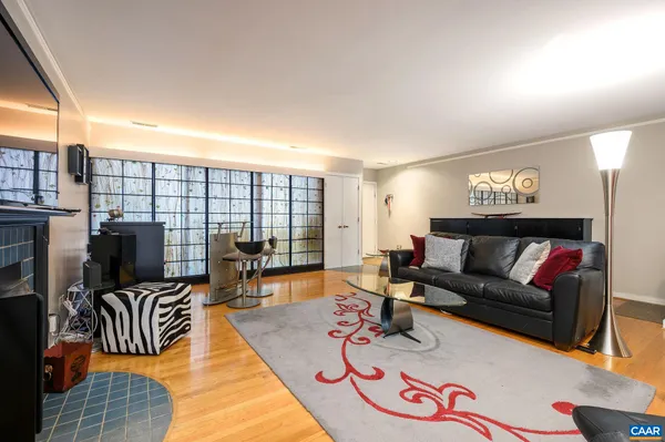 a living room with furniture kitchen view and large windows