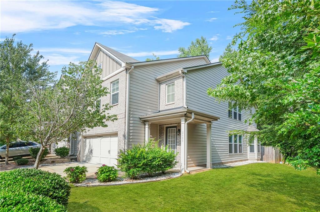 a front view of a house with a yard and trees