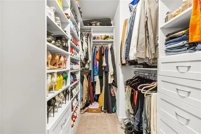 a view of walk in closet with clothes