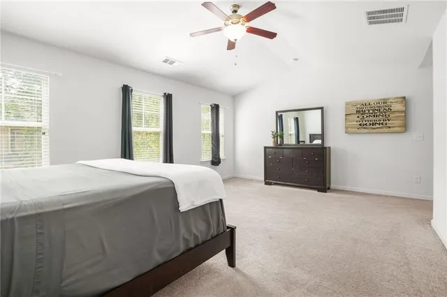 a spacious bedroom with a bed and a chandelier