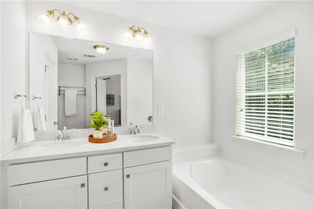 a bathroom with a tub sink and mirror