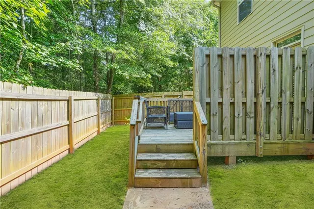 a view of a wooden deck and a yard with the trees