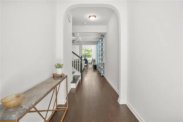 a view of a hallway with wooden floor and staircase