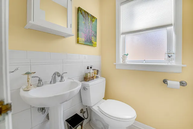 a bathroom with a toilet a sink and mirror