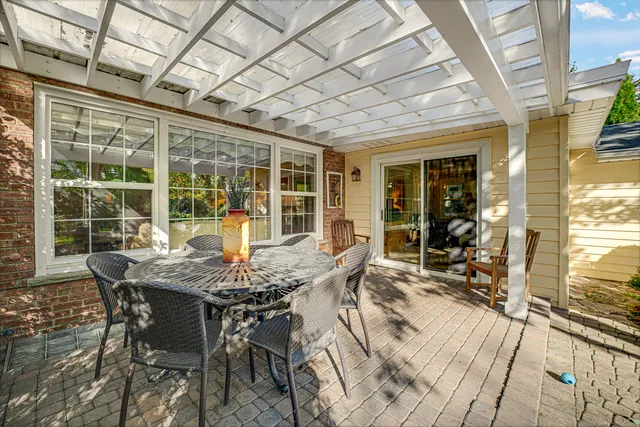 a view of a patio with table and chairs and wooden floor