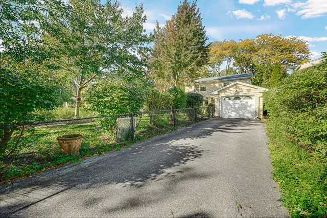 a front view of a house with a yard and fountain