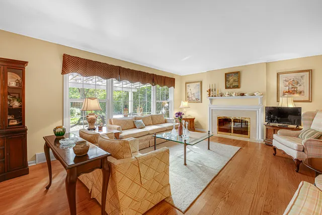 a living room with fireplace furniture and a large window