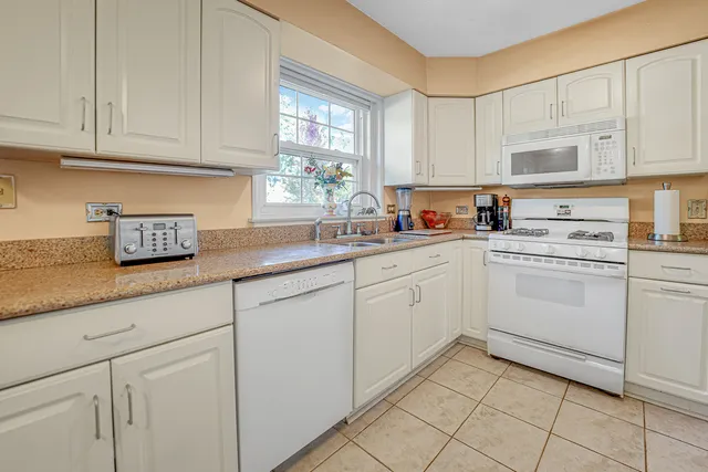 a kitchen with cabinets appliances a sink and a window
