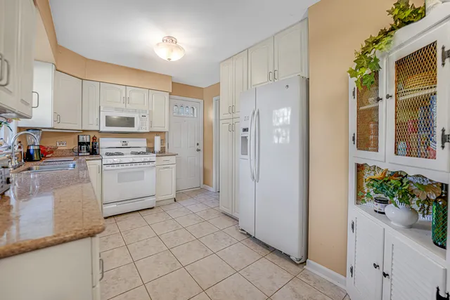 a kitchen with white cabinets and white appliances