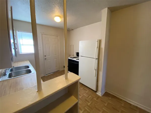 a view of a kitchen with a refrigerator and a sink