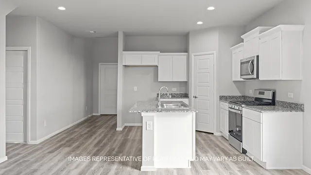 a kitchen with a stove a sink and a refrigerator