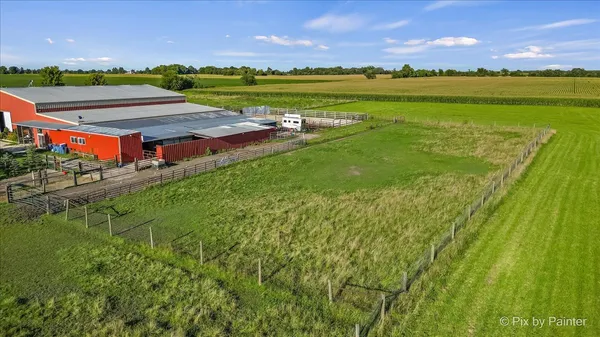 a view of a lake with lawn chairs and a big yard