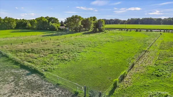 an aerial view of a house with a garden and lake view