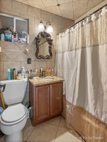 a bathroom with a sink a toilet and shower curtain