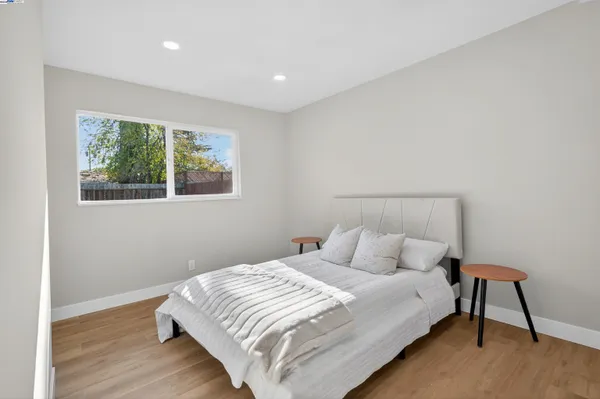 a bedroom with a bed and a lamp next to a window