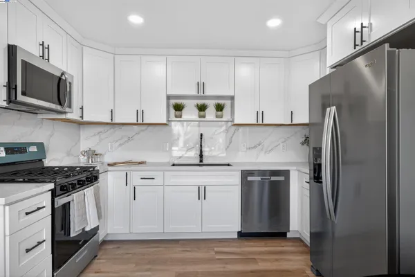 a kitchen with stainless steel appliances granite countertop a stove a refrigerator and a microwave