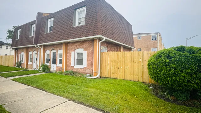 a view of a brick house with a yard