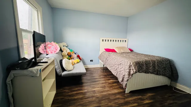 a bedroom with a bed dresser and window