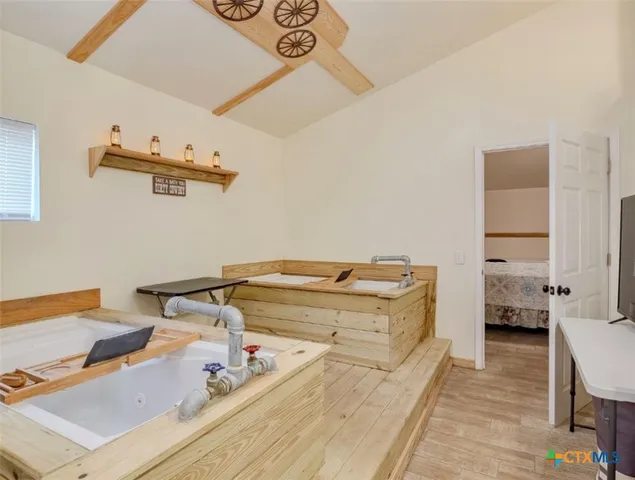 a spacious bedroom with a bed and wooden floor